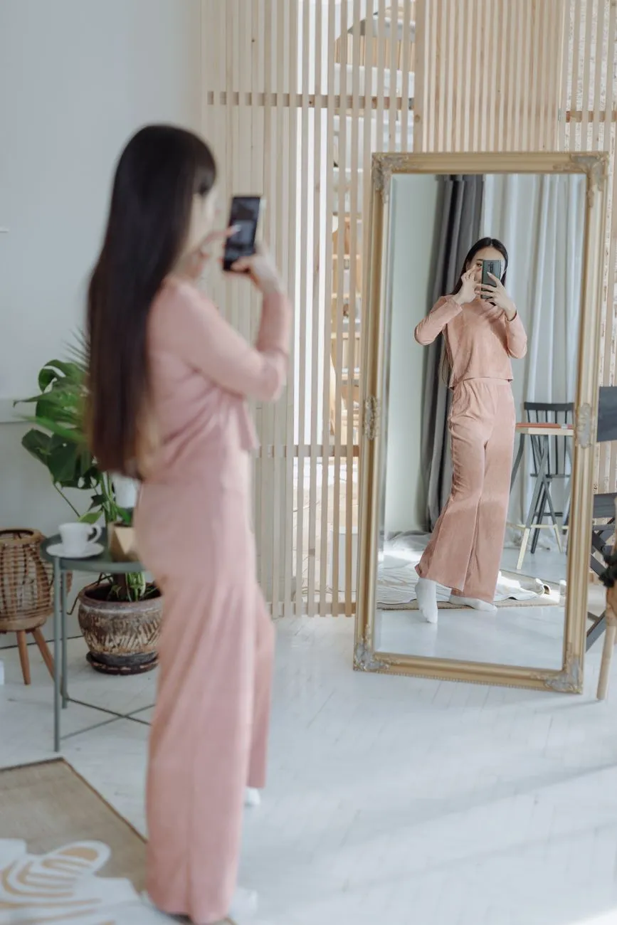 Cô gái chụp ảnh gương toàn thân bằng điện thoại trong phòng sáng